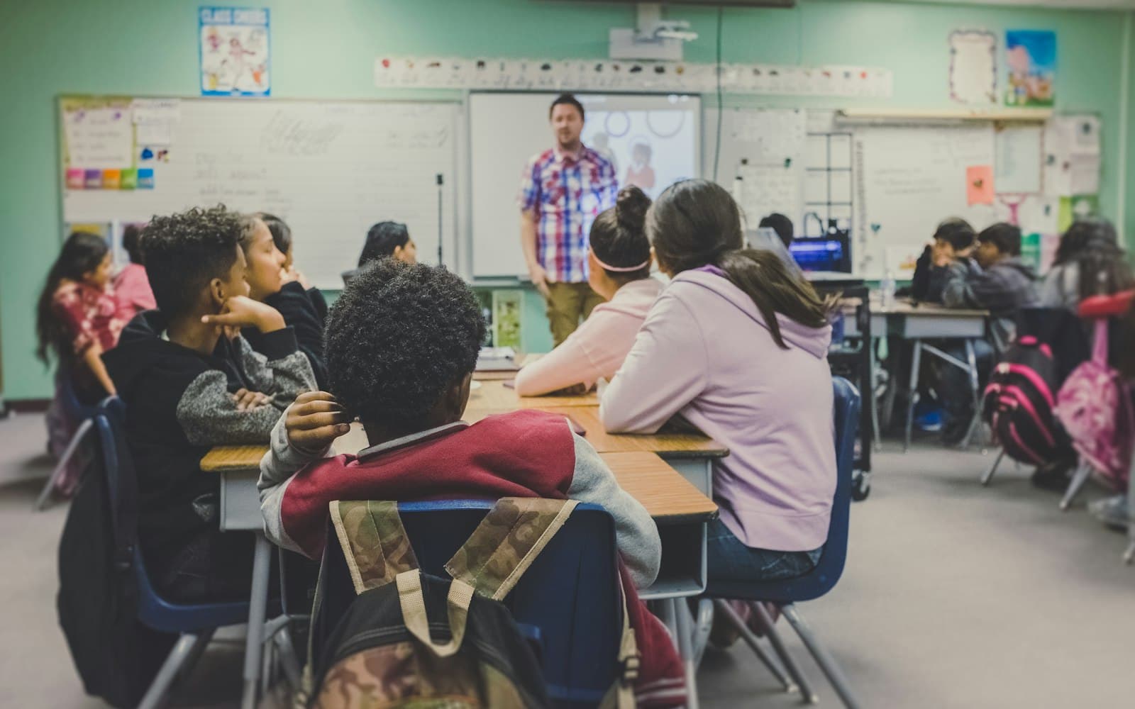A teacher at the board — after the demo, the next message should be a person, not a second bot loop.