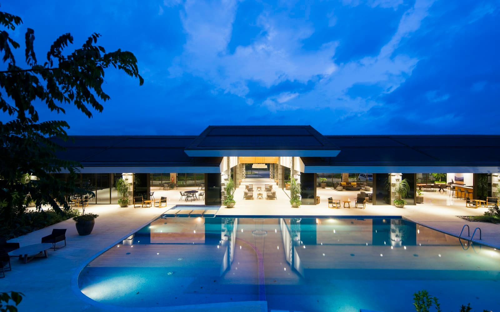 A hotel pool at dusk — guest relations still talks to a person, not a booking-engine ticket.