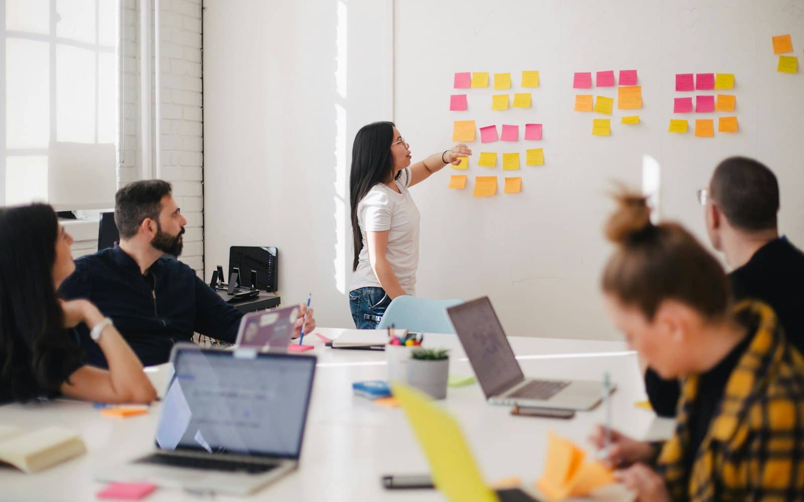 A workshop team mapping a buying decision on the wall — WhatsApp inbox versus a desk that also holds batches, vehicles and listings.
