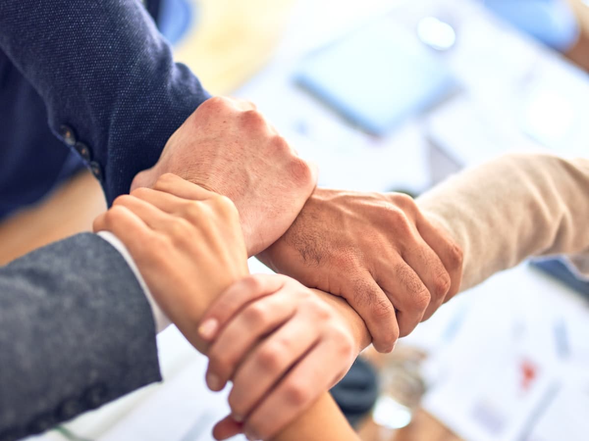 Team members joining hands in partnership