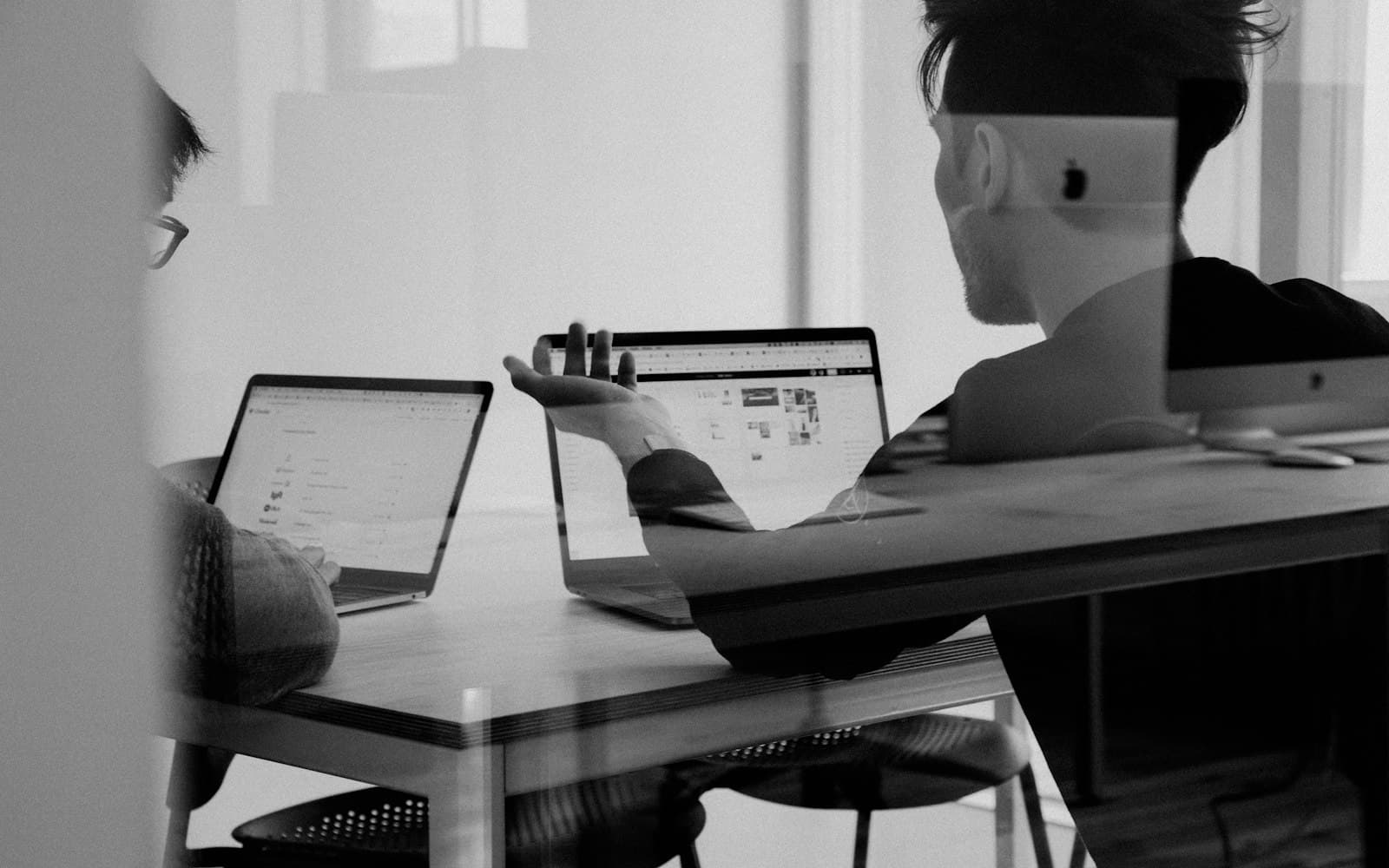 Colleagues reviewing a screen — waiting-on-you is a CRM state, not a guilt trip in the group.