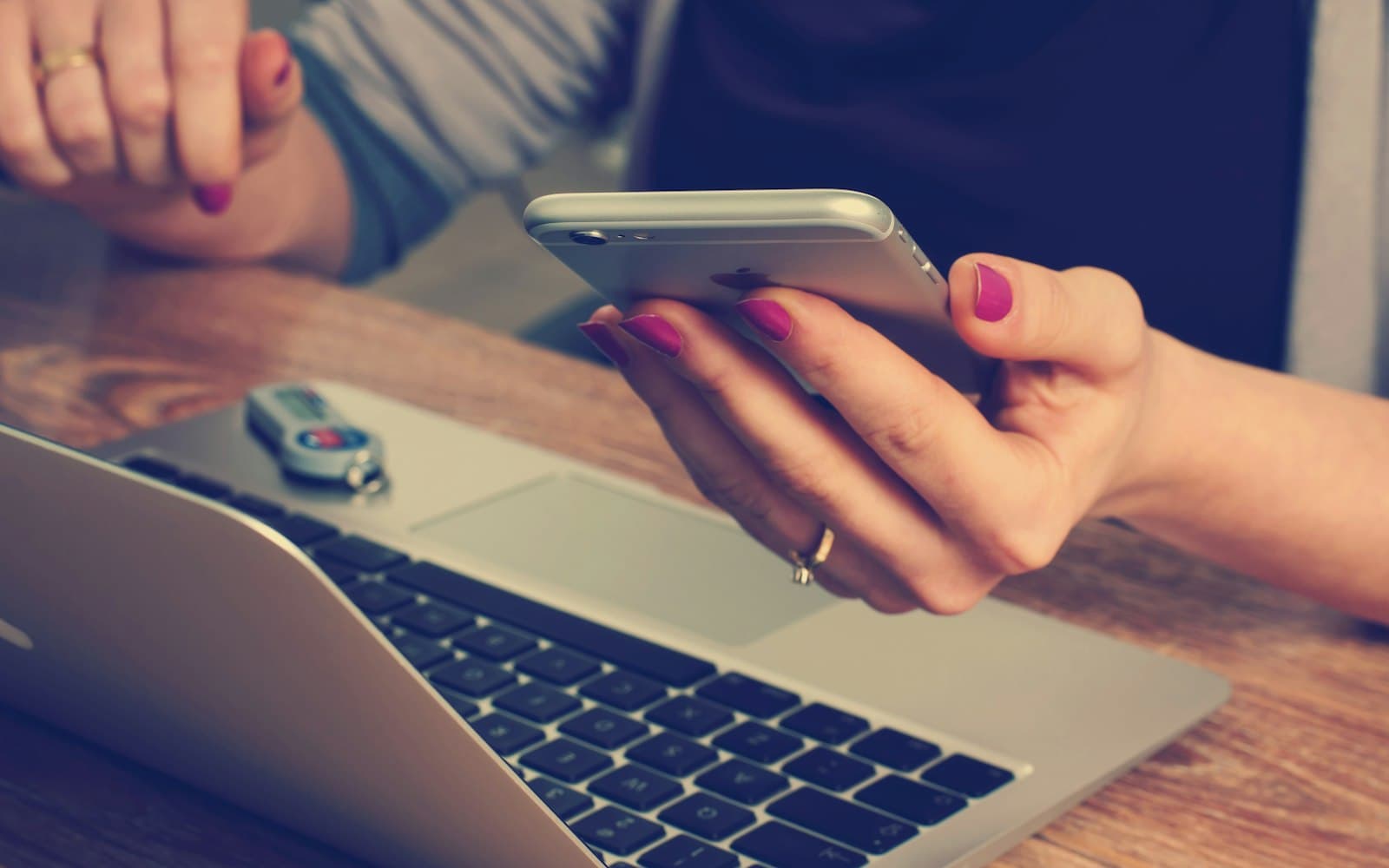 A phone next to a laptop — the call has to land on the same person as the WhatsApp thread, or the desk is lying.