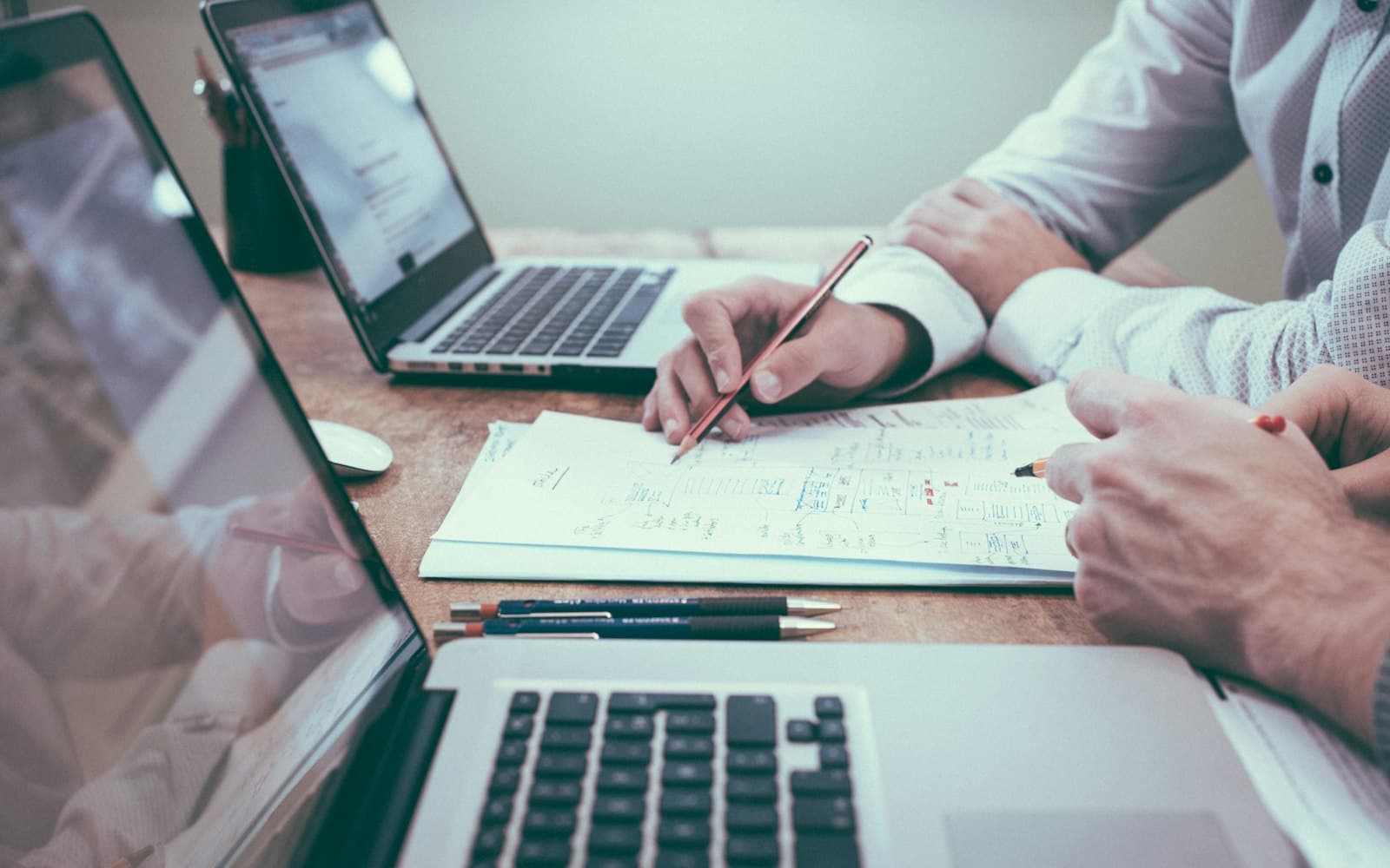 Two people working a file at a desk — chase the missing PDF; do not paste a full account number into WhatsApp.