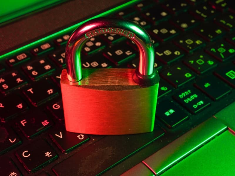 A padlock resting on a backlit keyboard, symbolizing secure key management